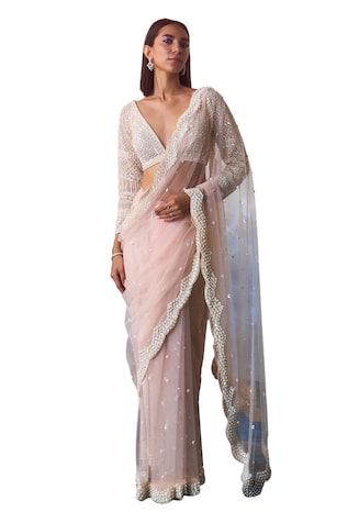 Light peach scallop border net saree with misty pearls and tonal sequins embroidered details. Paired with a full sleeves plunging V neck blouse with all over pearl, sequin, beads floret jaal embroidery  and a petticoat. - Aza Fashions Elegant Sheer Saree For Wedding, Luxury Semi-stitched Net Pre-draped Saree, Festive Sheer Saree For Wedding, Festive Sheer Wedding Saree, Semi-stitched Net Pre-draped Saree, Peach Pre-draped Saree For Wedding, Semi-stitched Net Pre-draped Saree With Sequins, Elegant Peach Saree With Sheer Dupatta, Designer Pre-draped Pearl Embroidered Saree