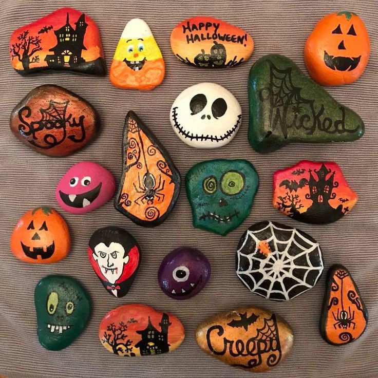 painted rocks with halloween decorations on them are arranged in the shape of pumpkins and jack - o - lanterns