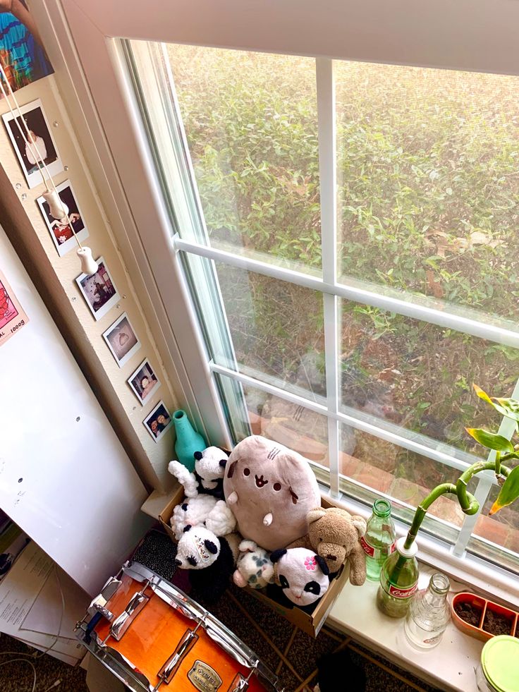 there is a stuffed animal on the window sill with other stuff animals in front of it