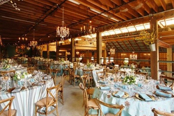 an indoor dining area with tables, chairs and chandeliers set up for a formal function