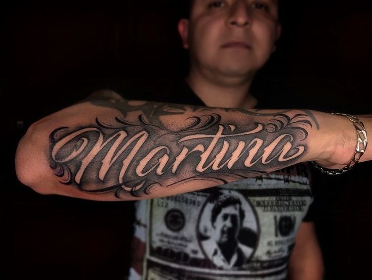 a man with a tattoo on his arm that says marinane in cursive writing