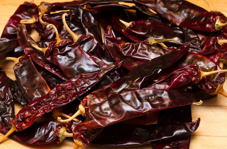 some red peppers are sitting on a cutting board