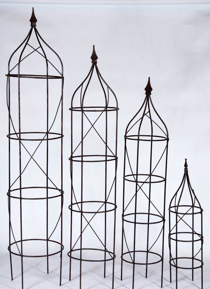 four metal cages are lined up against a white backdrop, each with an individual's own design