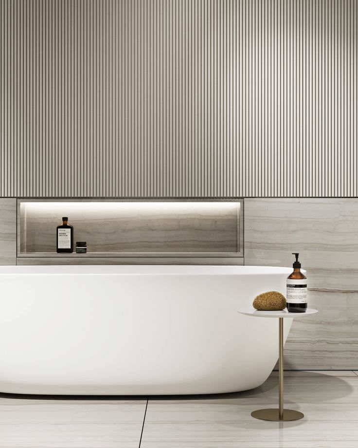 a white bath tub sitting in a bathroom next to a wall mounted shower faucet