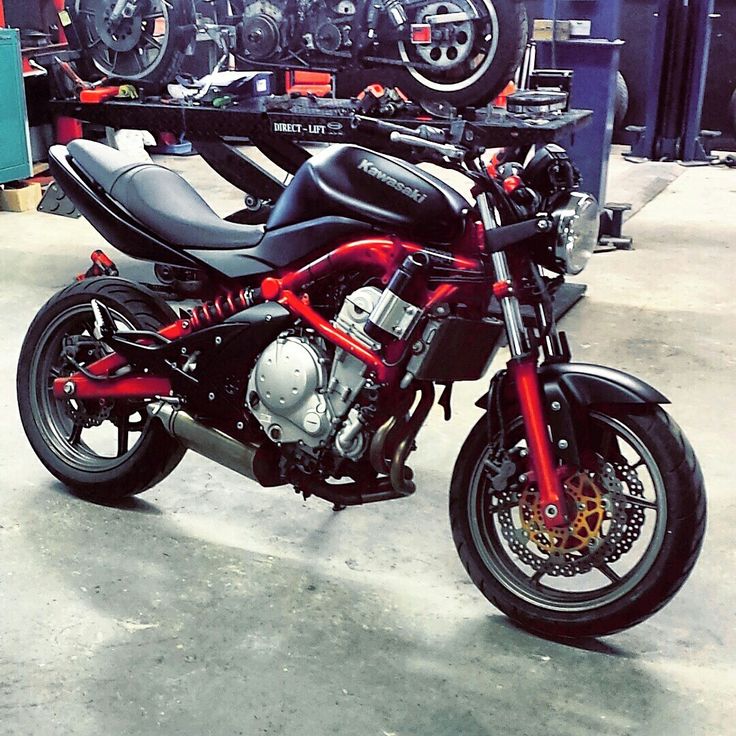 a red and black motorcycle parked in a garage