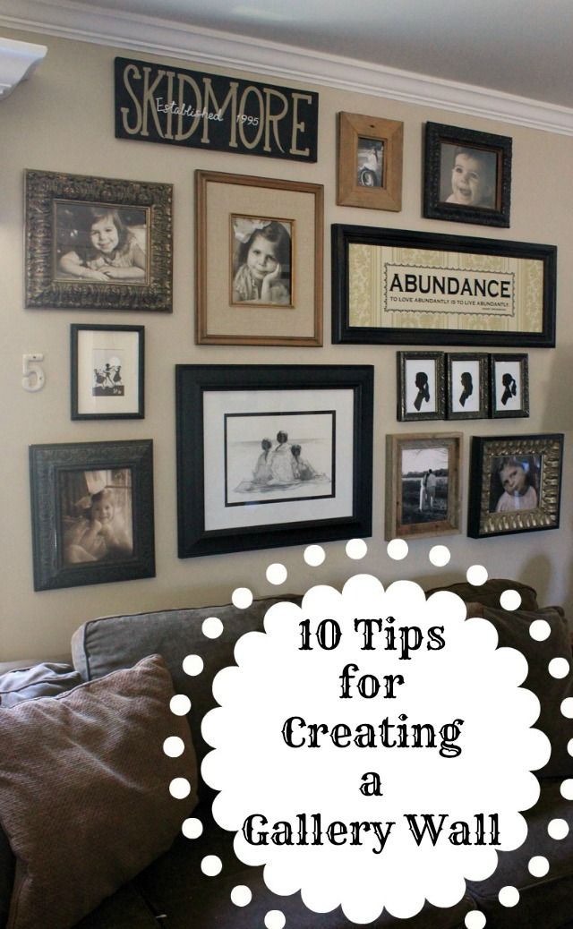 a living room filled with lots of framed pictures on the wall above a brown couch