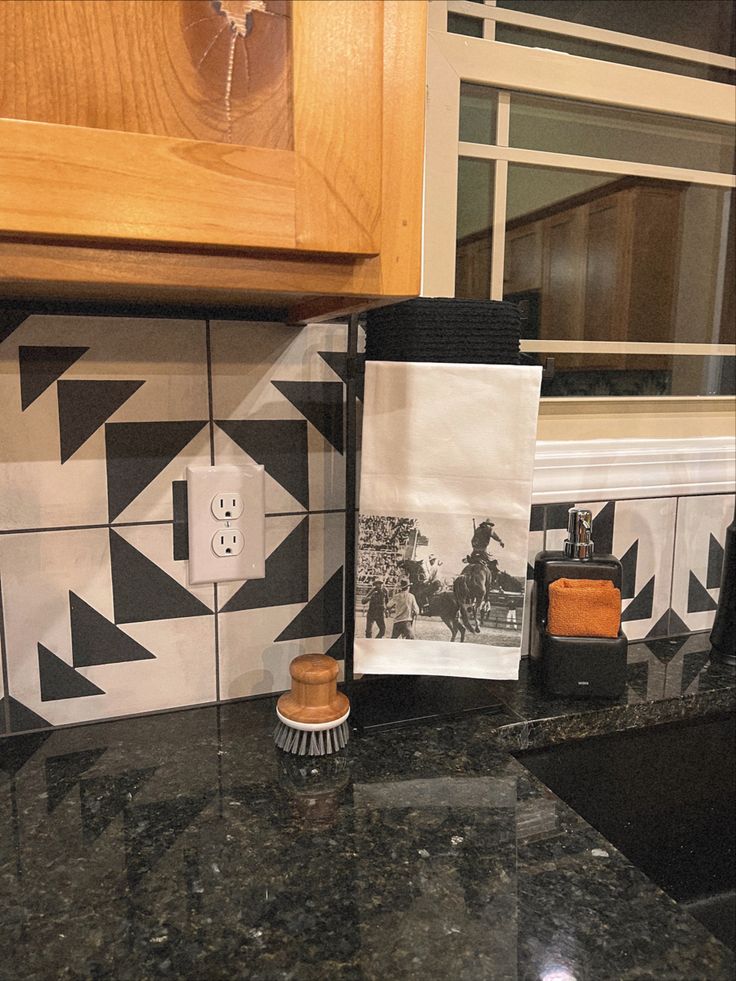 the kitchen counter is covered with black and white tiles