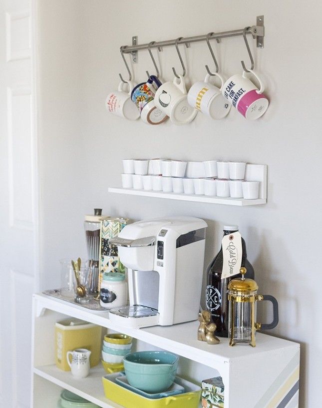 a coffee bar with cups and mugs hanging on the wall