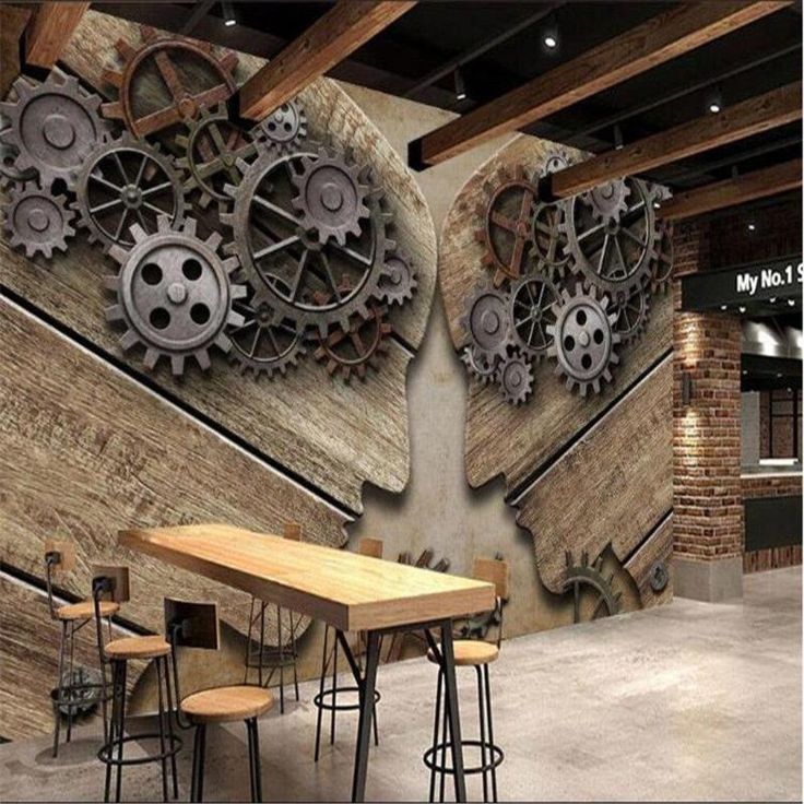 an industrial style dining room with gears on the wall and wooden tables in front of it