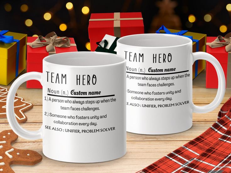 two coffee mugs sitting on top of a table next to christmas decorations and presents