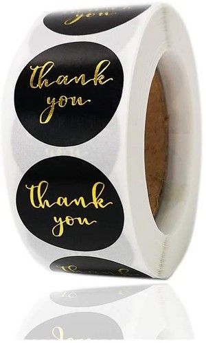 a roll of black and white thank you stickers with gold foil lettering on them