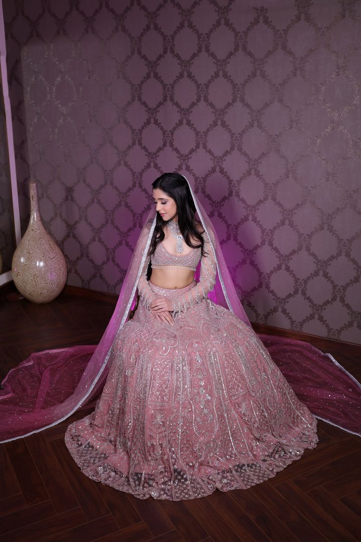 A modern bridal lehenga hand embellished with pearls, crystals, sequin, and cutdana embroidery. Paired with a full sleeves embroidered blouse with all-over dangling tassel detailing on the sleeves and an embroidered cutwork dupatta with a border. Additional dupatta available upon request.DELIVERY TIMEPlease allow 8-12 weeks for your outfit to arrive.FABRIC DETAILSNetProfessional cleaning only. Glamorous Gown With Sheer Dupatta For Festive Occasions, Glamorous Festive Gown With Sheer Dupatta, Embellished Lehenga For Reception With Traditional Drape, Bollywood Style Hand Embellished Saree For Wedding, Glamorous Designer Wear Hand Embellished Sharara, Glamorous Hand Embellished Saree For Wedding, Glamorous Embellished Lehenga For Eid, Glamorous Hand Embellished Dupatta For Reception, Glamorous Sets With Dupatta For Reception