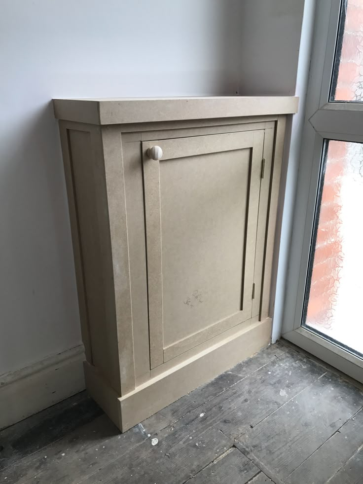 a corner cabinet next to a window in a room