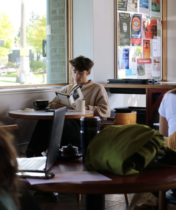 a man sitting at a table reading a book