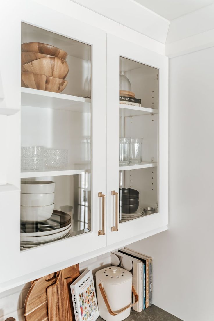 a kitchen with white cabinets and wooden utensils