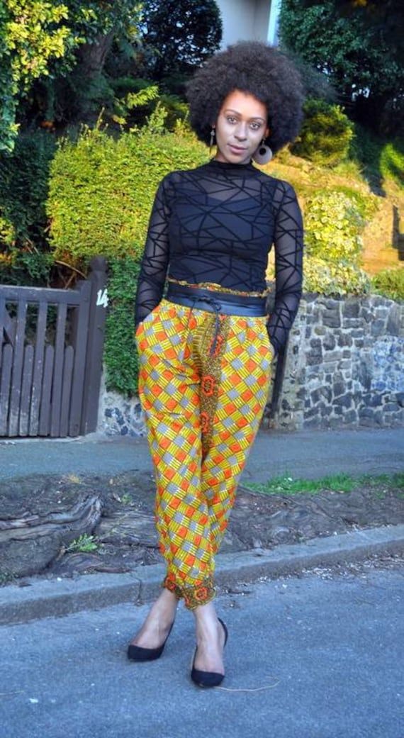 "Joggers in African print with mustard and orange as the primary colours. It has deep side pockets and the fit is relaxed with an elasticated waist making sizing flexible. Model 5ft9\" and wears a UK 10/12.  Belt available in shop to order. Length- 40\" 100% cotton  Made in Ghana Fabric care  Wash in cool water. Iron on medium heat.  Dry away from sunlight." Ghana Fabric, Primary Colours, Balloon Pants, Womens Trousers, Womens Pants, Trouser Pants, African Print, Ghana, Trousers Women