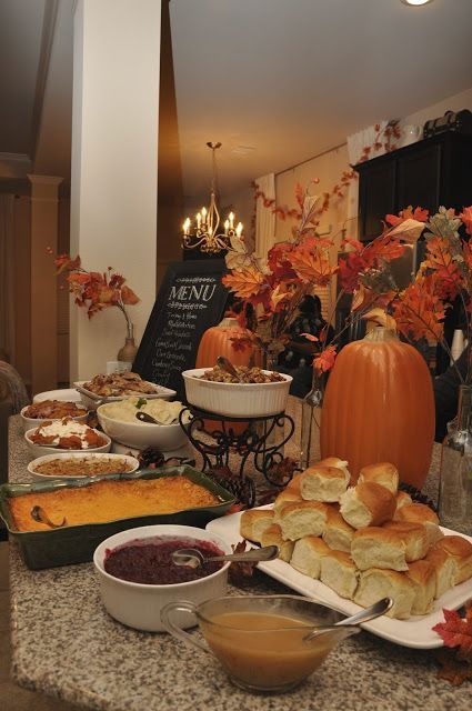 a table filled with lots of food on top of a kitchen counter next to a pumpkin