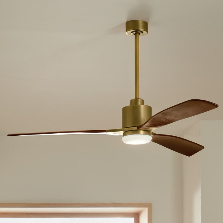 a ceiling fan with two light bulbs and a wooden blade in a white living room