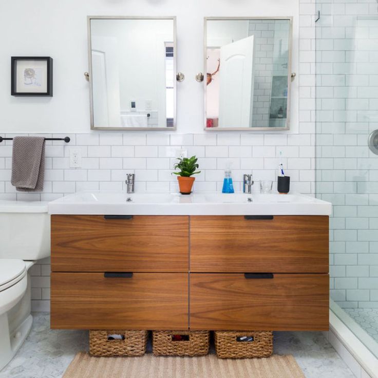 a bathroom with two sinks, a toilet and a large mirror on the wall above it