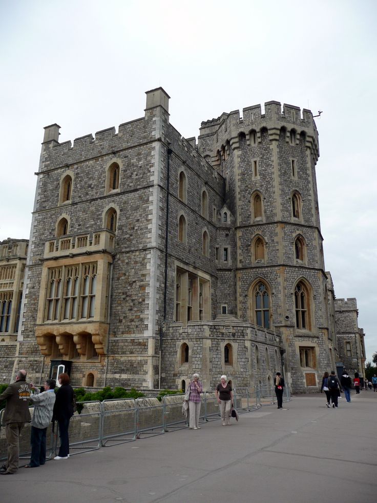 people are standing in front of an old castle