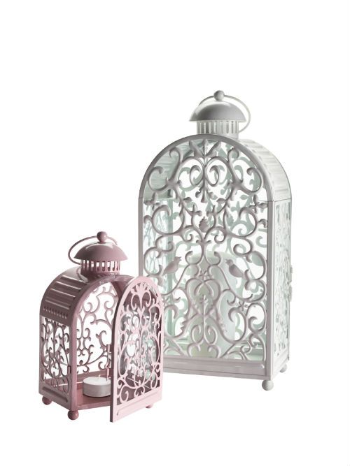 two white lanterns with intricate designs on the top and bottom, one has a candle in it