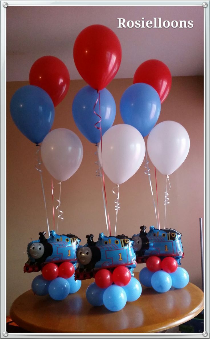 thomas the tank engine birthday cake with balloons and train cars on it's top