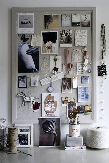 a bulletin board with pictures, photos and yarn on it's sides next to a potted plant