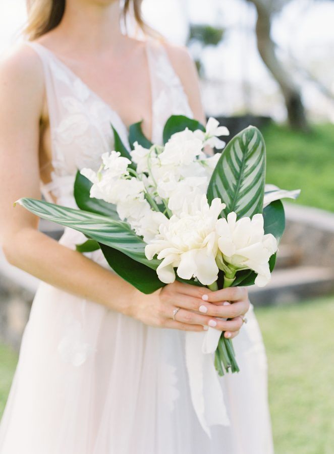 a woman holding a bouquet of white flowers