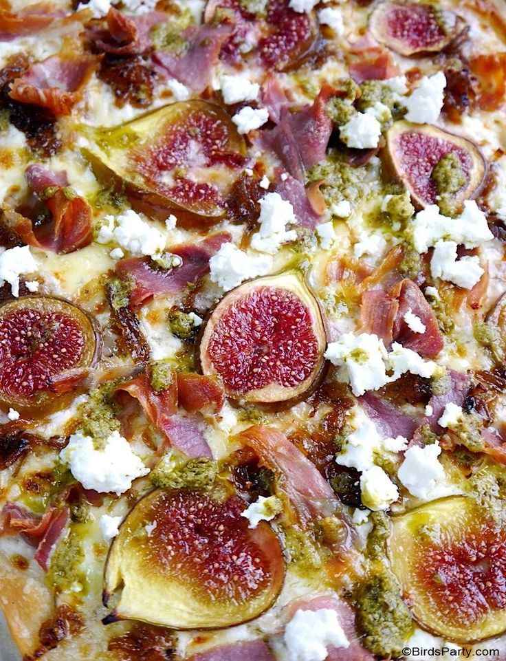 a pizza topped with figs, cheese and other toppings