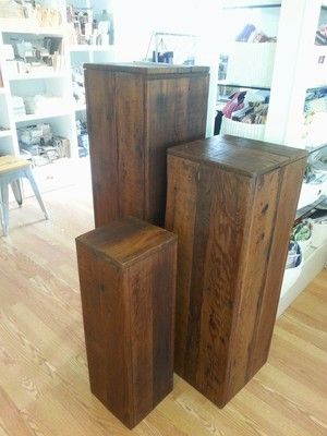 three wooden boxes are stacked on top of each other in the middle of a room