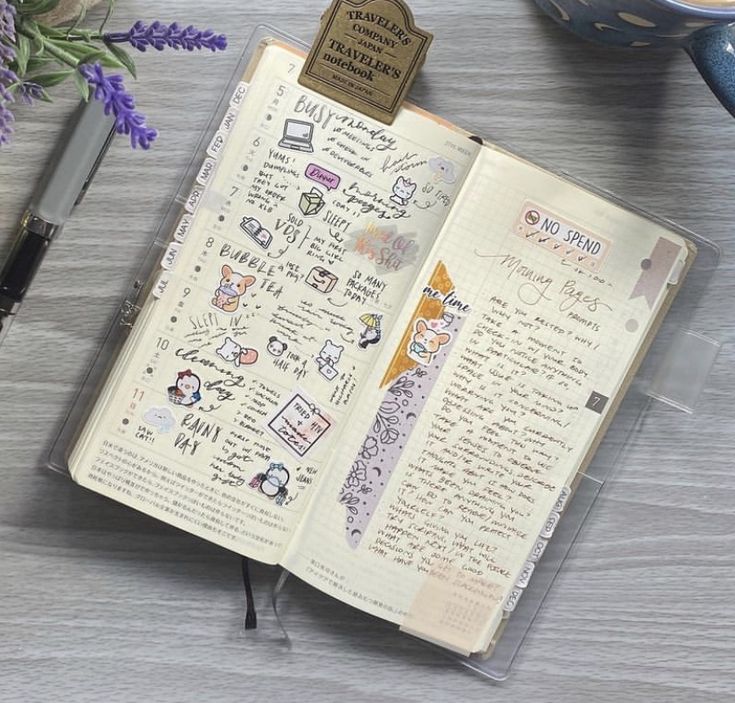 an open notebook with stickers on it next to a cup of coffee and flowers