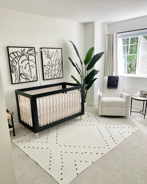 a baby's room with a crib, chair and pictures on the wall