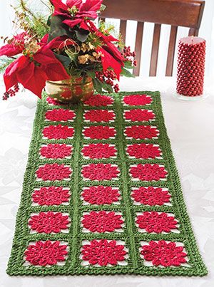 a crocheted table runner with poinsettis on it