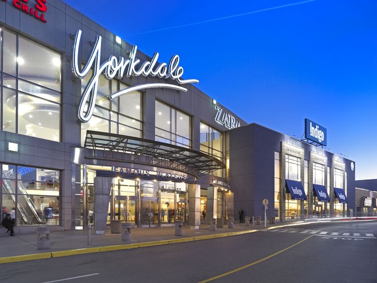 an exterior view of a shopping center at night