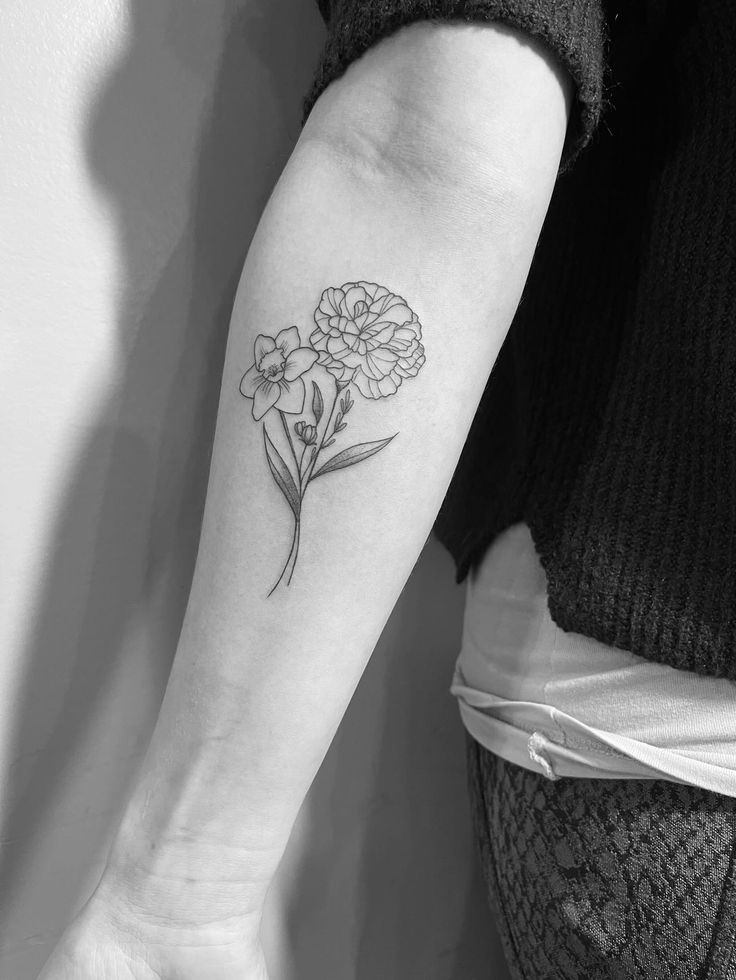 a woman's arm with a flower tattoo on the left side of her arm