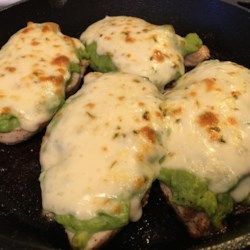 four pieces of food are being cooked in a skillet on the stove with melted cheese