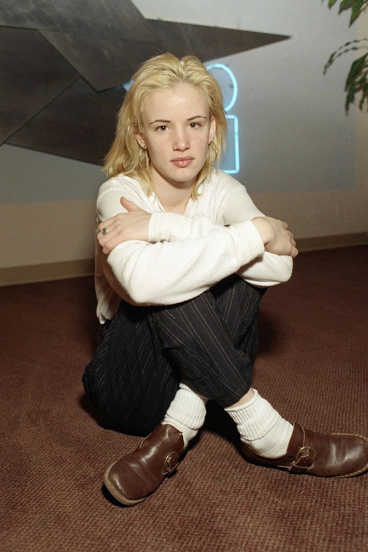 a woman sitting on the floor with her arms crossed