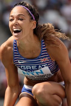 a woman is laughing while kneeling on the ground