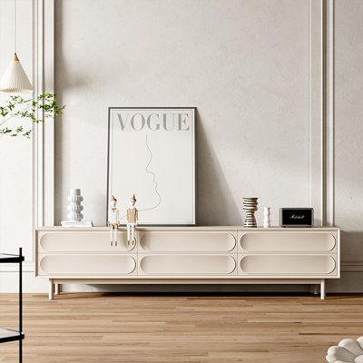 a living room scene with focus on the sideboard and vases in the foreground