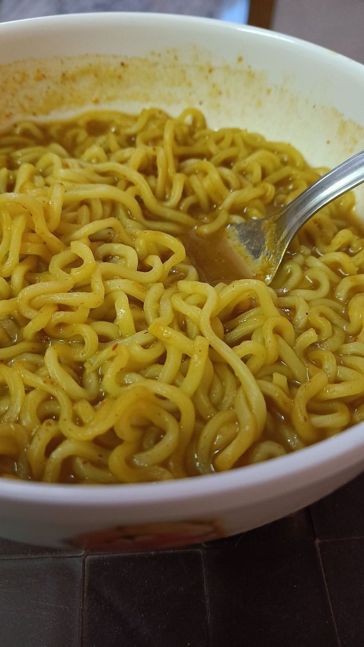 a bowl full of noodles with a spoon in it