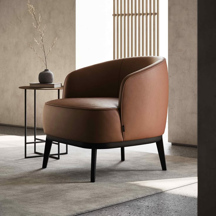 a brown chair sitting on top of a floor next to a table with a vase