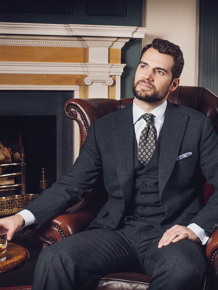 a man sitting in a chair wearing a suit and tie