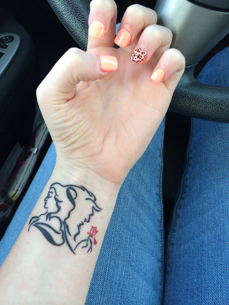 a woman's hand with a small tattoo on it