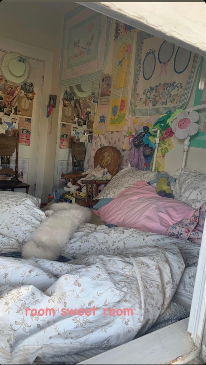 an unmade bed in a room with many pictures on the walls and flooring