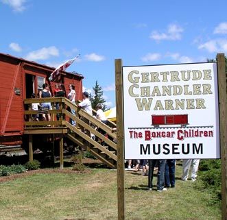 people standing in front of a red building with a sign that says the baxter children museum