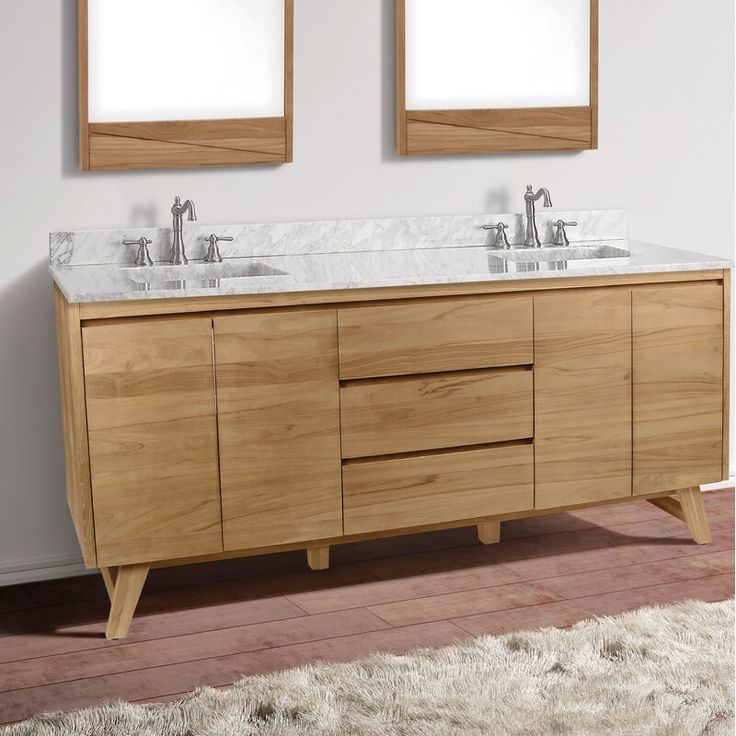 two mirrors are above the double sink vanity in this white and wood bathroom with rugs on the floor