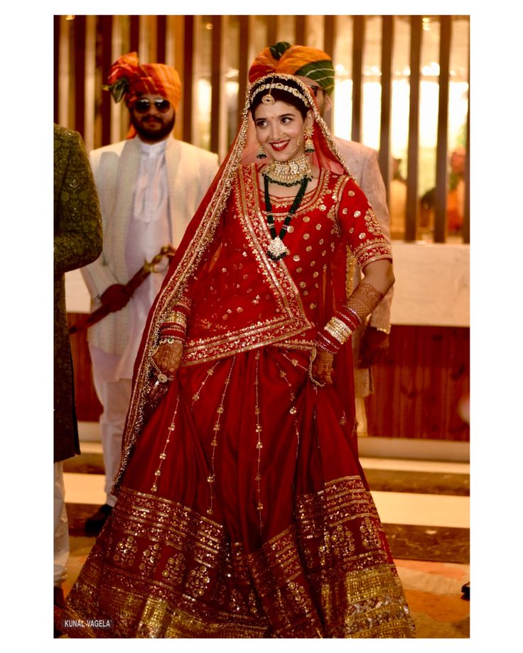 a woman in a red and gold wedding outfit