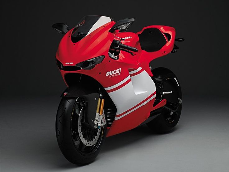 a red and white motorcycle parked on top of a gray floor