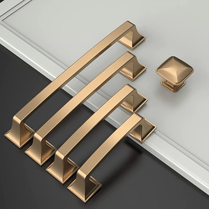 an assortment of brass handles and knobs on a white door with black flooring