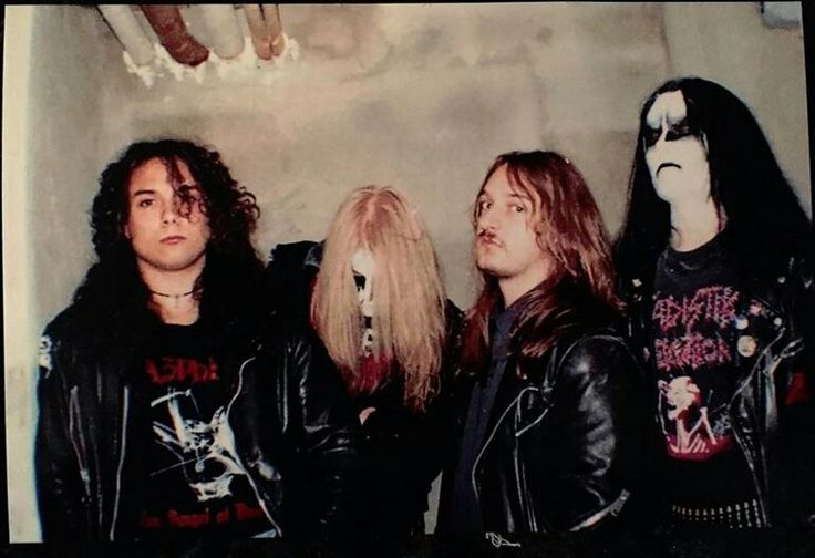 three men in leather jackets standing next to each other and one man with long hair